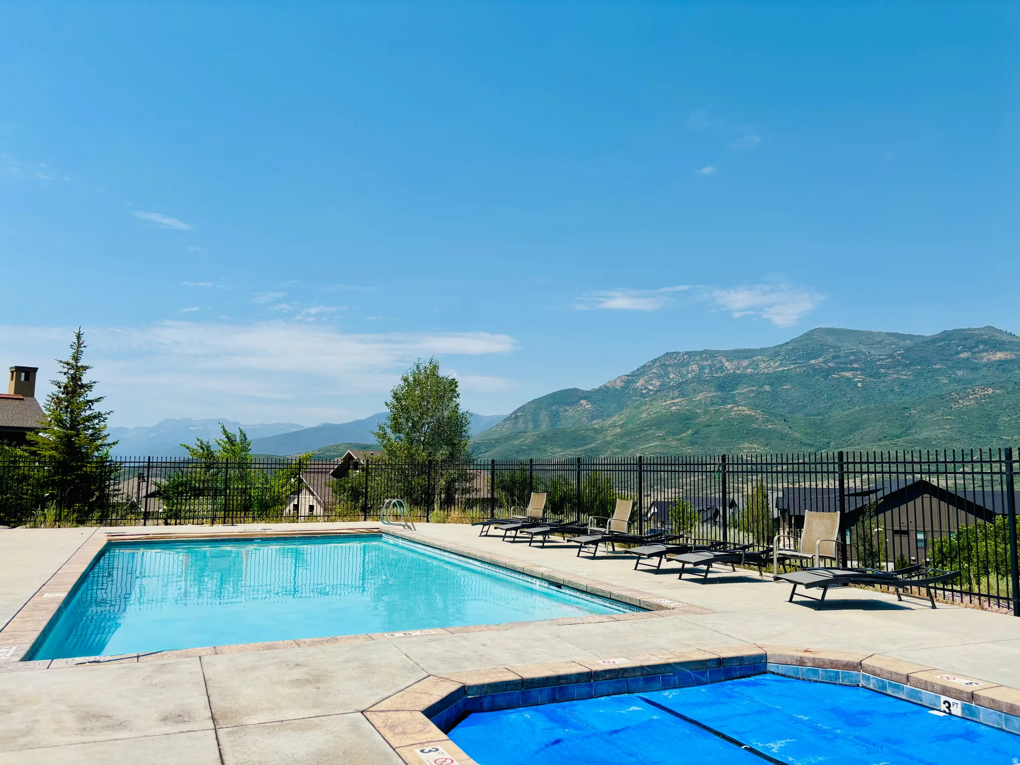 Outdoor swimming pool with concrete decking and mountain scenery