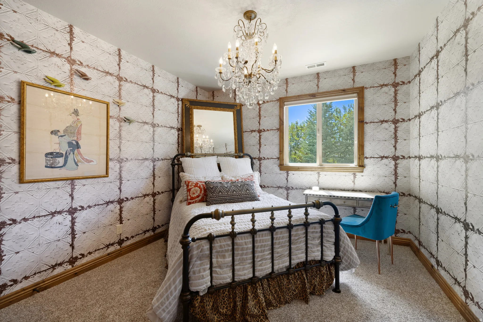 Bedroom featuring textured wall covering, a crystal chandelier, wood-trimmed window, and neutral carpet flooring