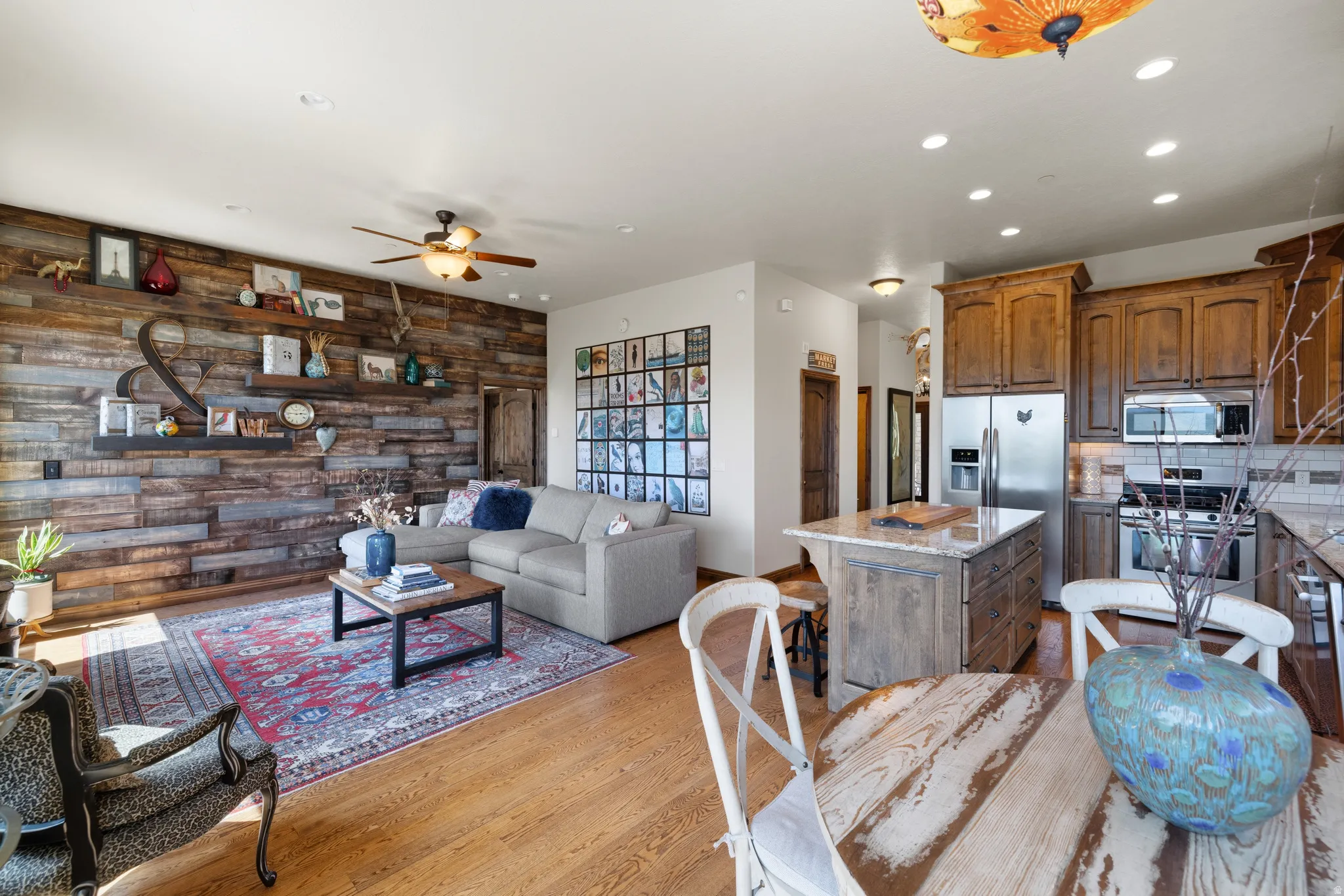 Open-concept living space featuring wood-finish flooring and a wood plank accent wall