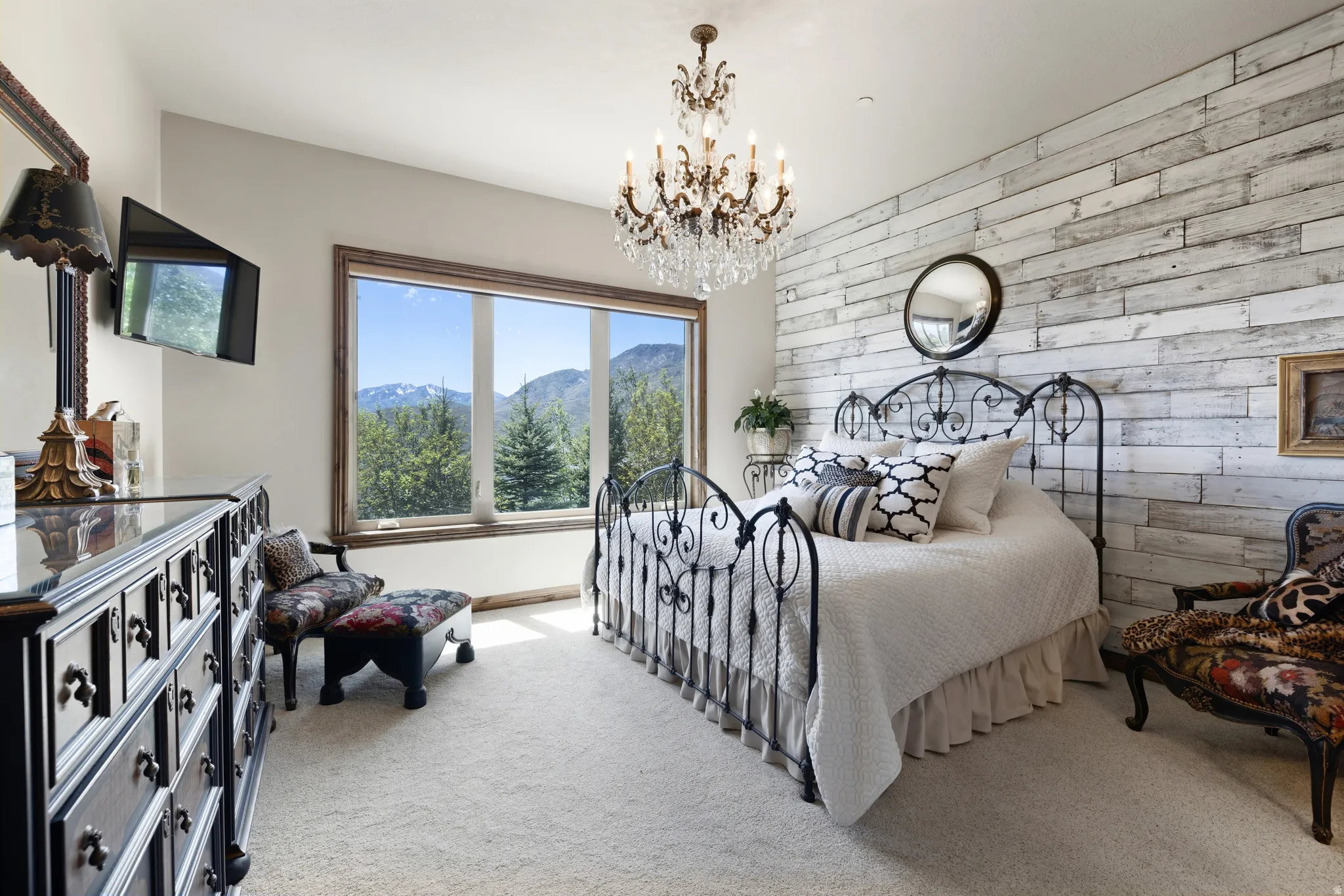 Room featuring a large picture window, wood-finish window trim, and a white wood-paneled accent wall