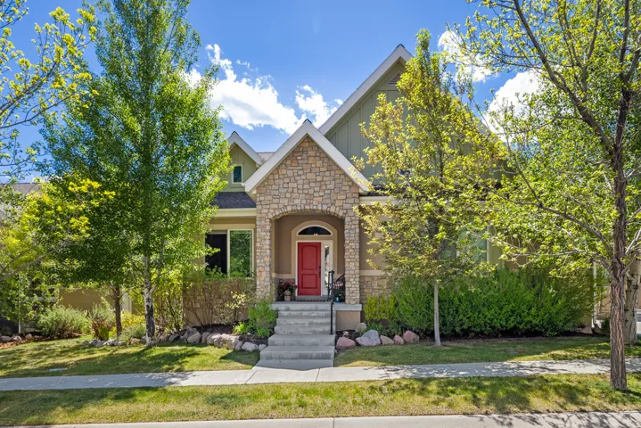 Traditional-style residence featuring a prominent stone facade and a vibrant red entry door