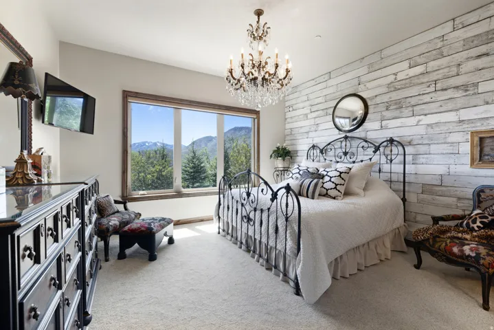 Room featuring a large picture window, wood-finish window trim, and a white wood-paneled accent wall