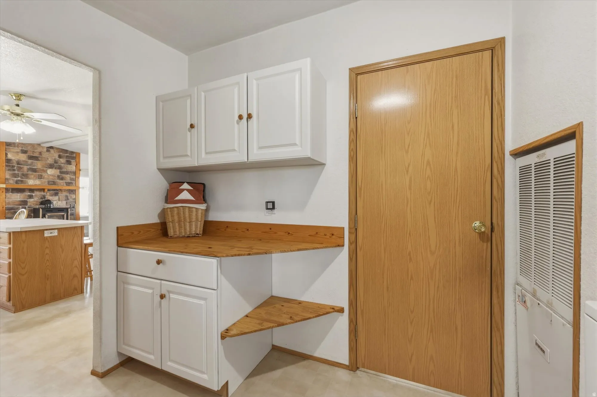White cabinetry with wood-finish countertops and integrated shelving