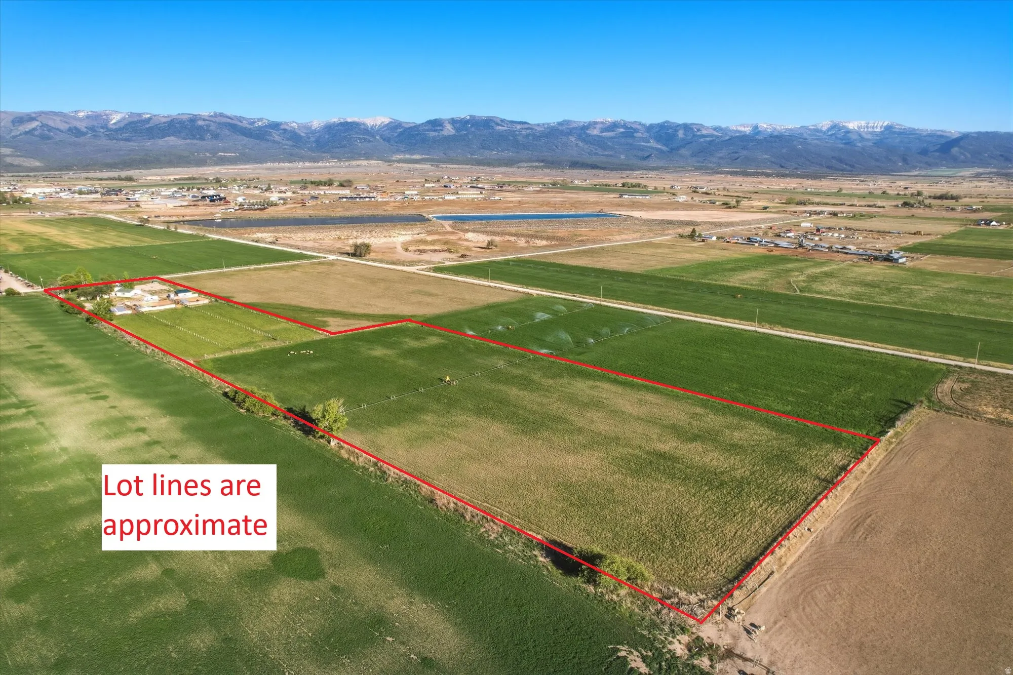 Expansive rural property featuring a large parcel of cleared land with established green fields