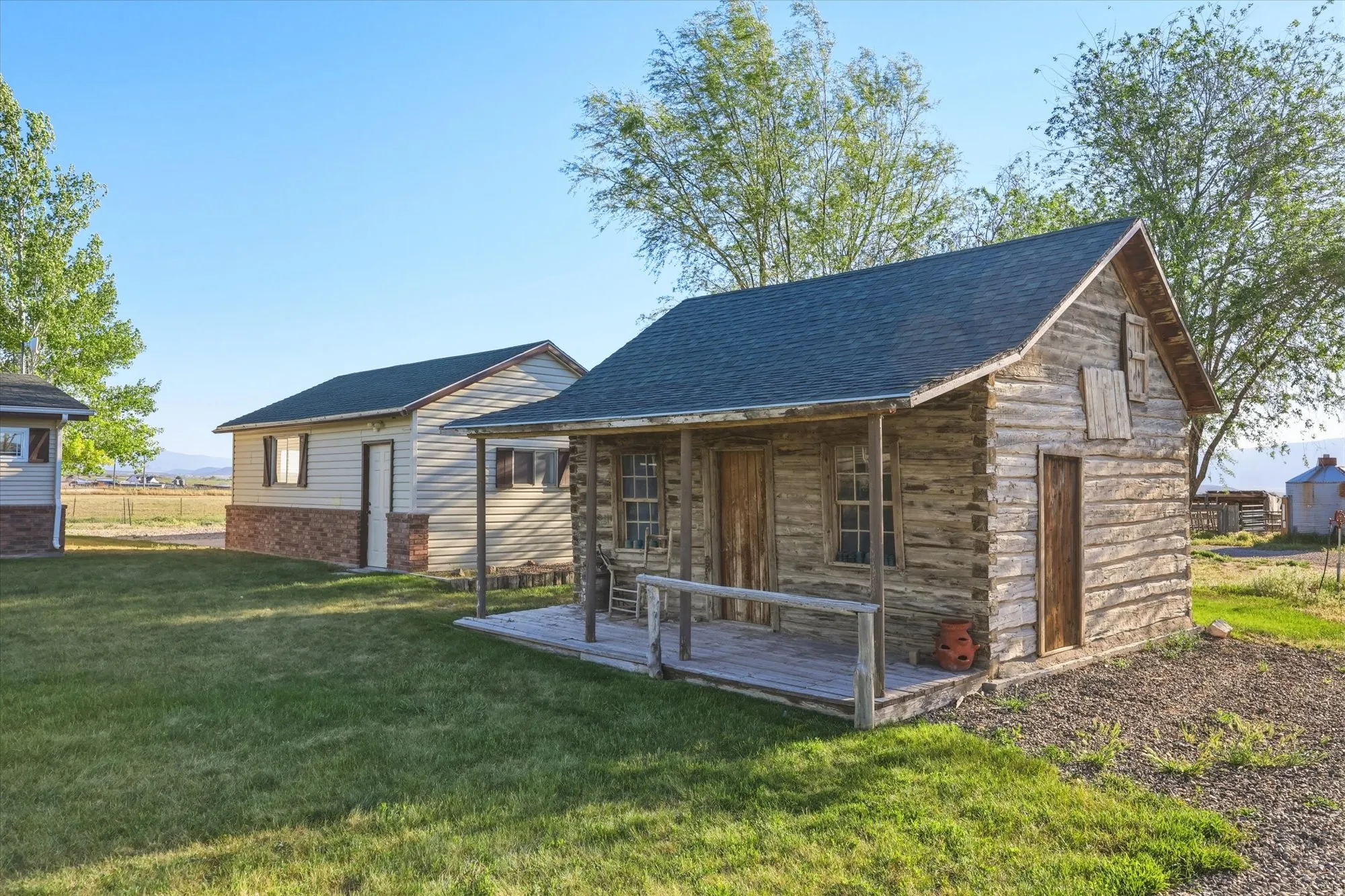 Rustic log cabin with a covered porch and traditional wood-frame windows