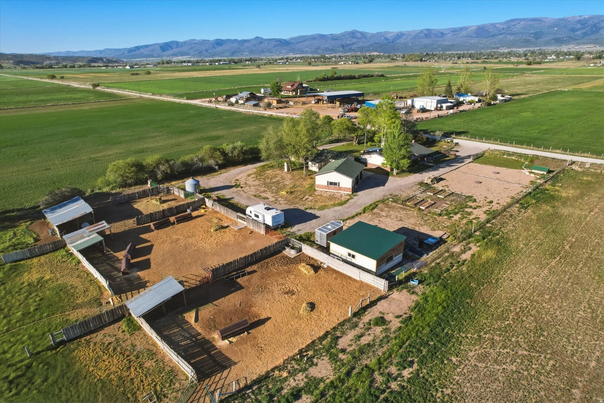 Expansive property featuring multiple outbuildings, fenced enclosures, and agricultural fields