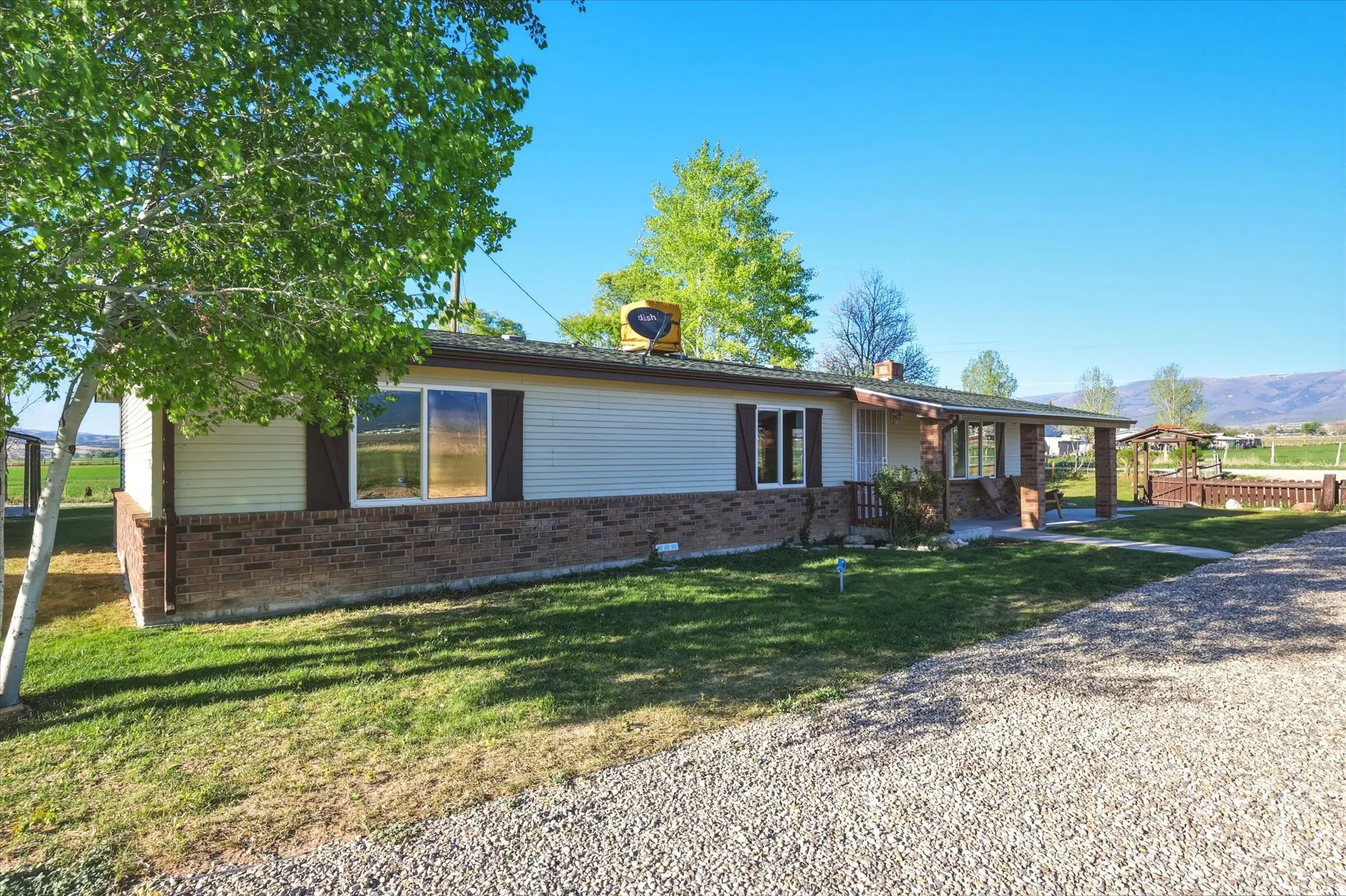 Single-story residence featuring light-colored siding and a brick-finish foundation