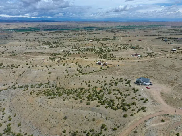 Expansive desert landscape featuring rolling terrain and scattered green shrubbery