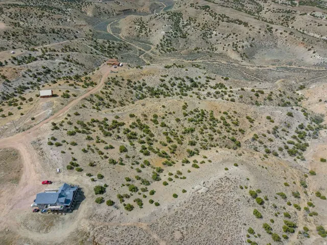 Expansive desert landscape featuring a multi-level residence with a dark roof and multiple outbuildings