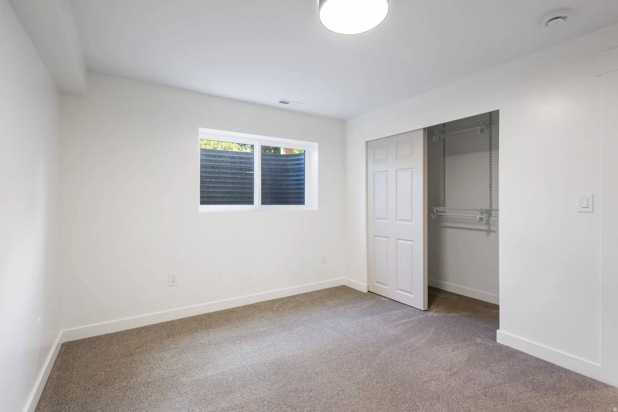 Neutral-toned carpeting extends throughout this room, complemented by white walls and trim