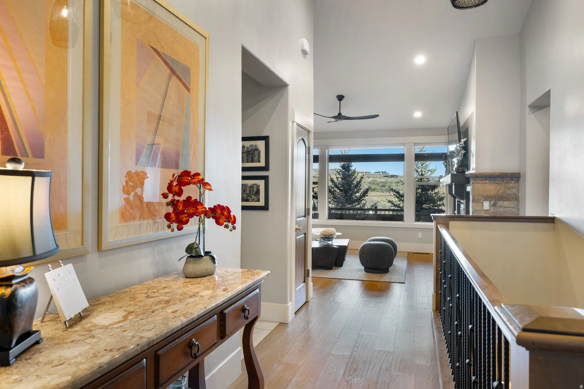 Hardwood flooring extending throughout the hallway, featuring a built-in console table with a stone countertop