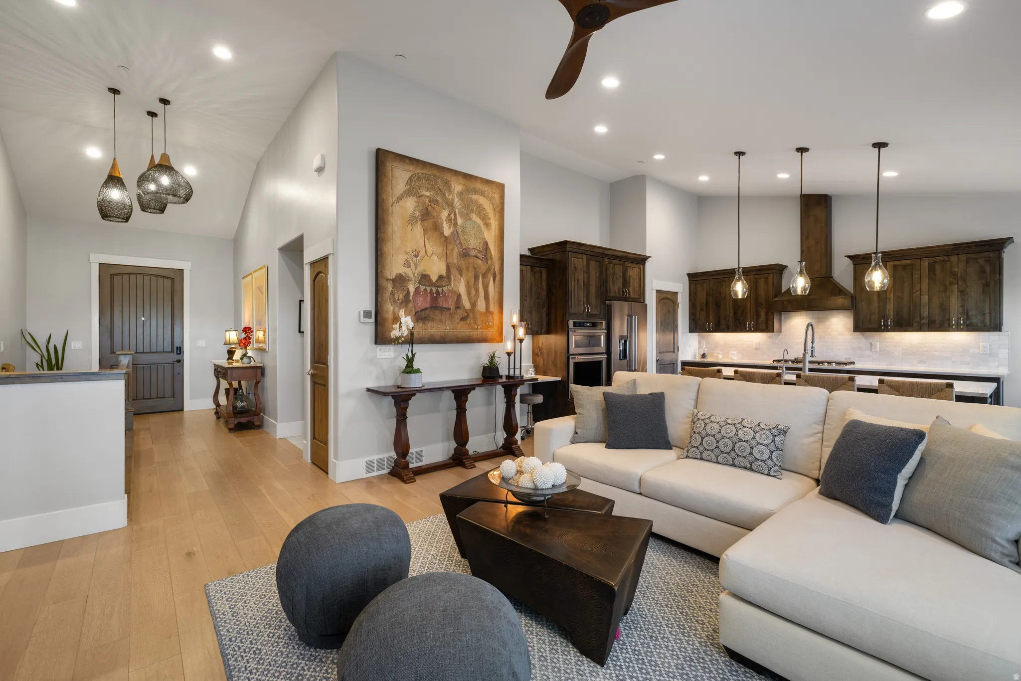 Open-concept living space featuring wood-finish flooring, recessed lighting, and a dark wood ceiling fan