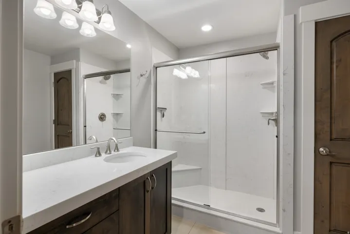 Bathroom featuring a dark wood-finish vanity with a white countertop, undermount sink, and brushed nickel faucet