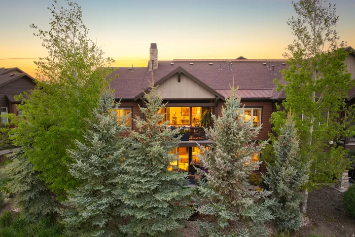 Multi-level dwelling with a dark wood-toned exterior and a dark shingle roof