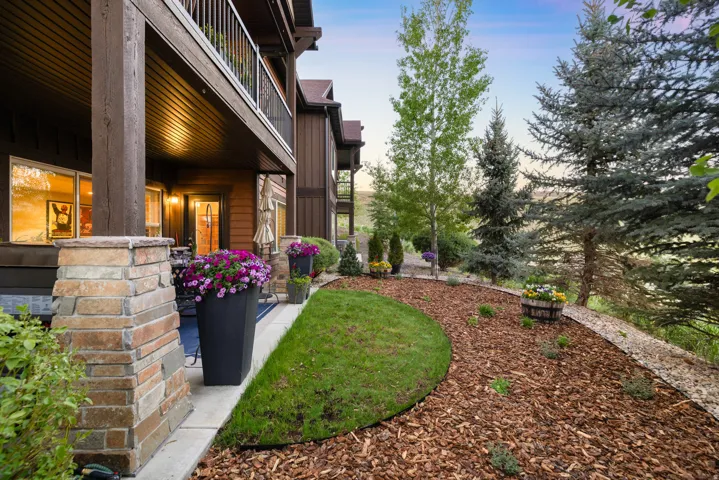 Covered outdoor patio with stone-wrapped columns and a wood-paneled ceiling
