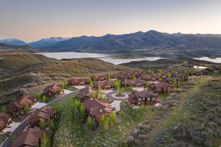 Community of multi-story homes featuring brown siding and dark roofs, arrayed along paved roads