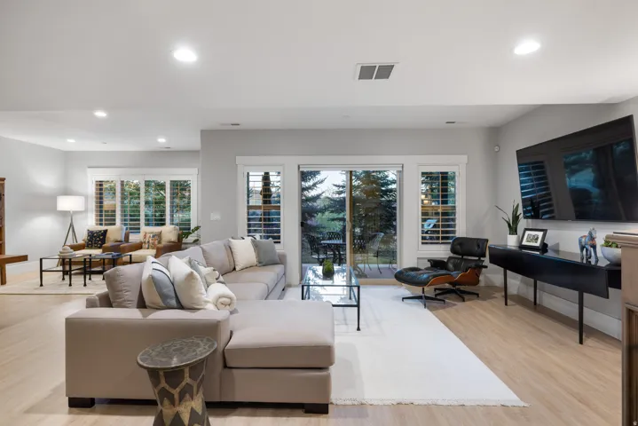 Spacious living area featuring light wood-finish flooring, recessed lighting, and light gray wall paint