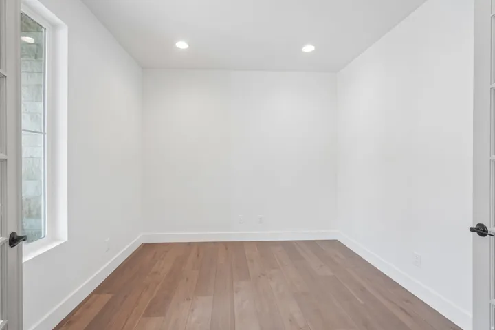 Bright room with wood-finish flooring and recessed lighting