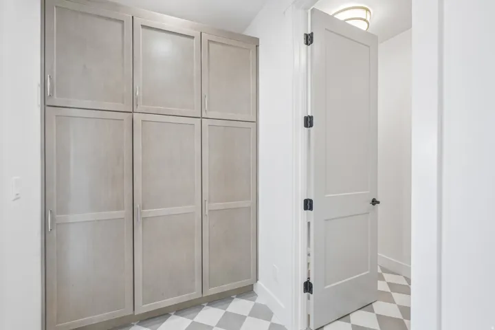 Full-height cabinetry with light wood-finish doors and brushed nickel hardware