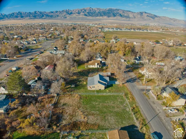 Expansive residential lot featuring a green lawn and mature trees, with a single-story residence present