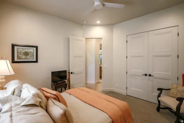 Recessed lighting, ceiling fan, paneled doors with dark hardware, and neutral carpet flooring