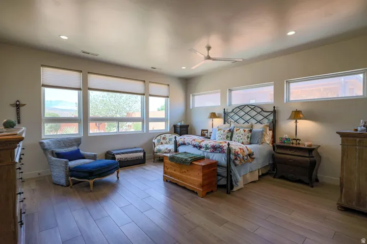Wood-finish flooring, recessed lighting, and multiple windows with privacy blinds