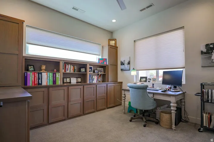 Built-in custom cabinetry with open shelving, recessed lighting, and expansive windows with privacy blinds