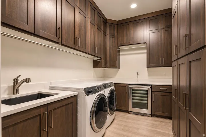 Extensive wood-finish cabinetry, light-toned countertops, and a built-in stainless steel beverage cooler