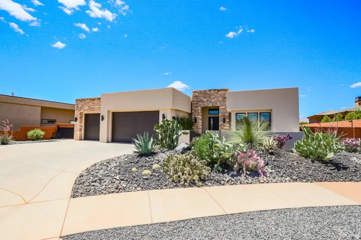 Contemporary desert architecture featuring a stucco exterior and stone accents