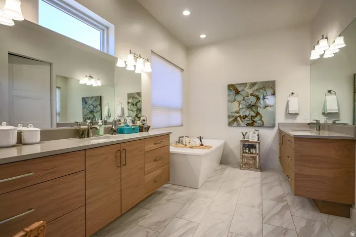 Floating wood-finish vanities with undermount sinks and light-toned countertops