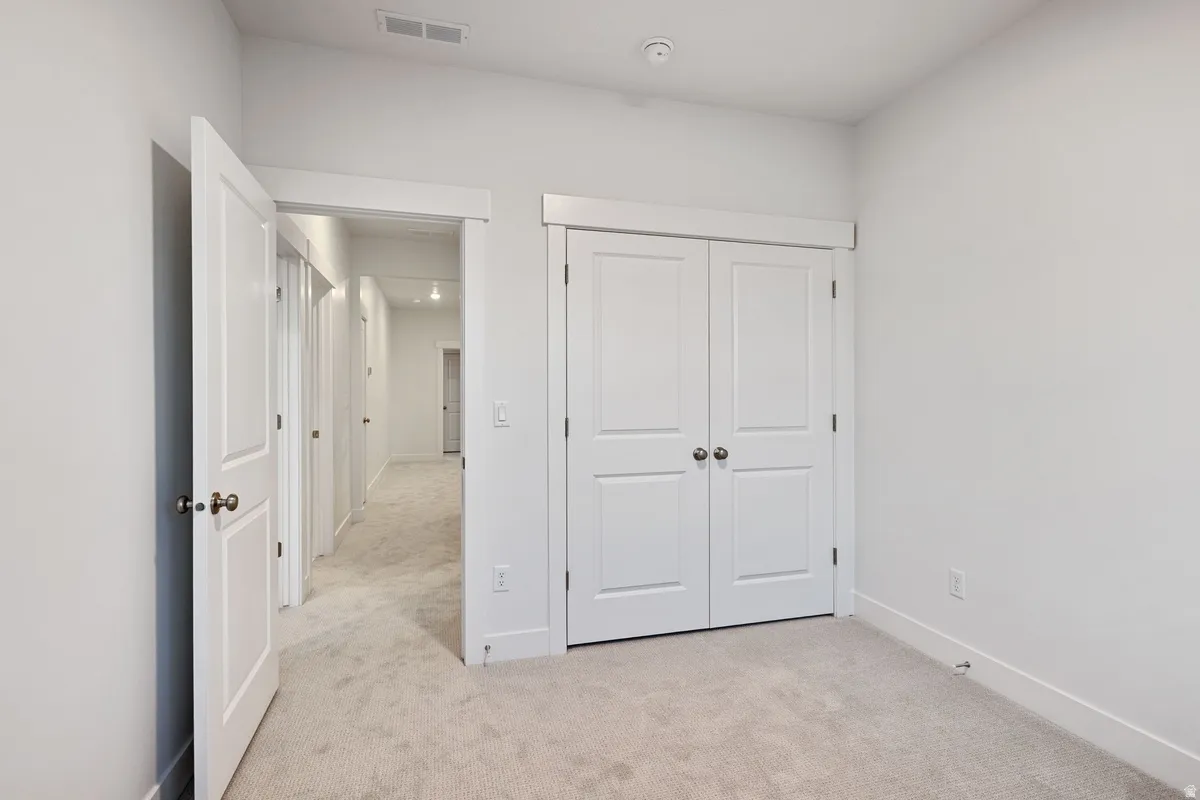 Room featuring light-colored carpeting and white walls