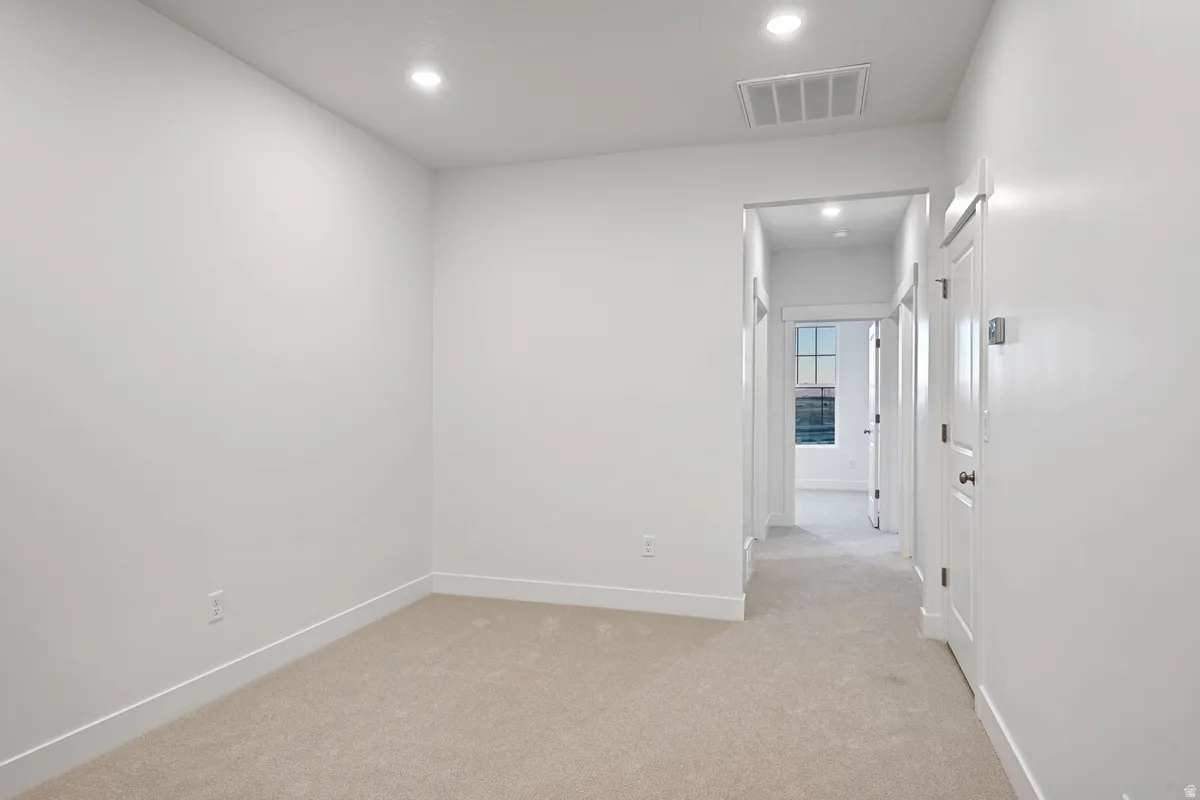 Carpeted interior space featuring recessed lighting and white baseboards