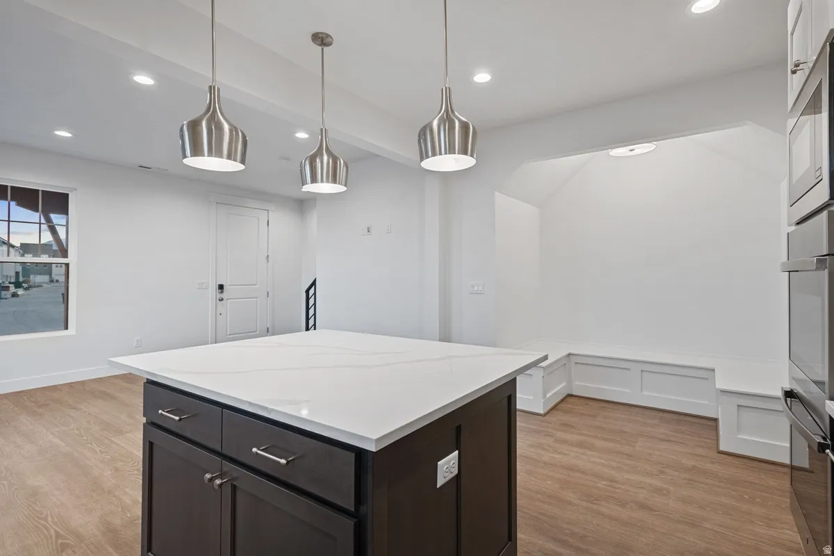 Central island featuring a white countertop and dark cabinetry