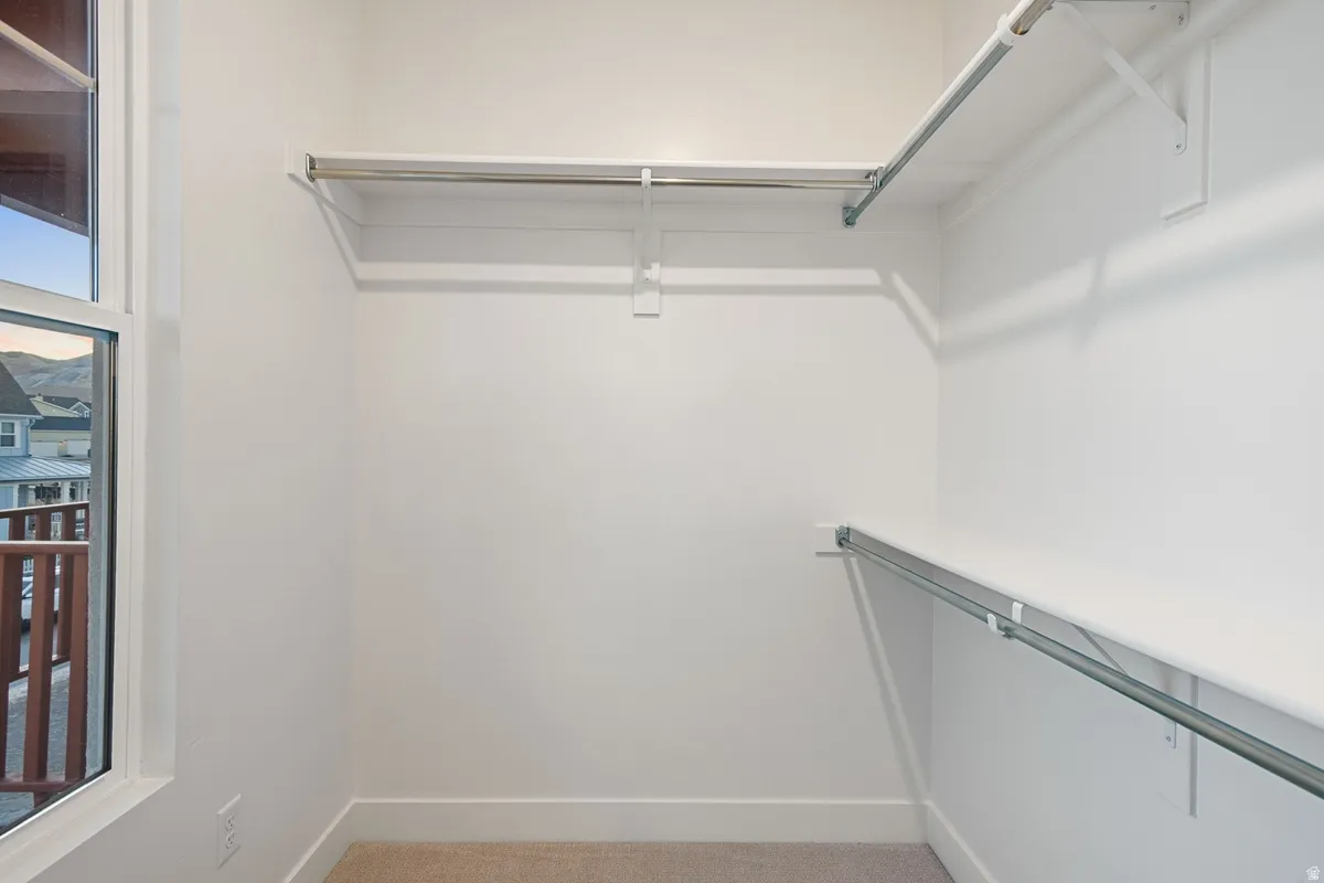 Walk-in closet featuring built-in shelving and hanging rods