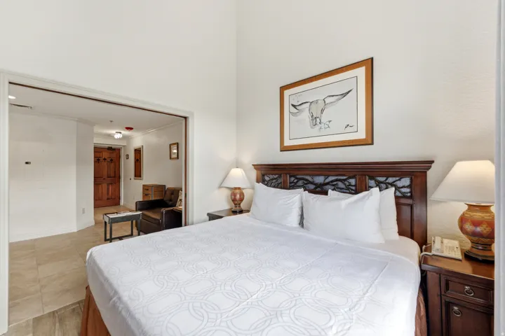 Bedroom featuring a dark wood headboard with carved detailing, neutral wall paint, and recessed lighting