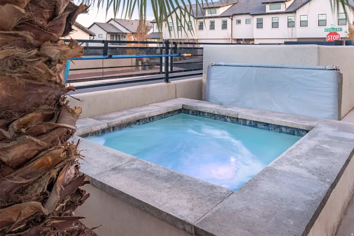 In-ground spa with stone coping and blue tile surround