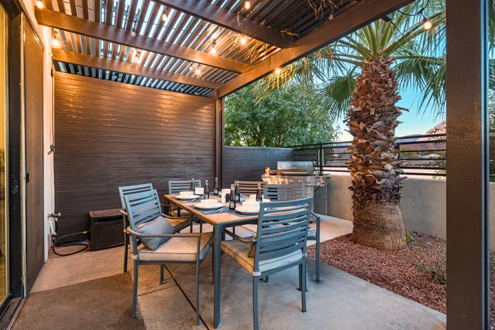 Covered patio featuring a wood slat pergola, string lighting, and concrete flooring