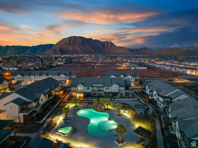 Resort-style community pool and spa surrounded by multiple multi-story residential buildings, with a prominent mountain backdrop