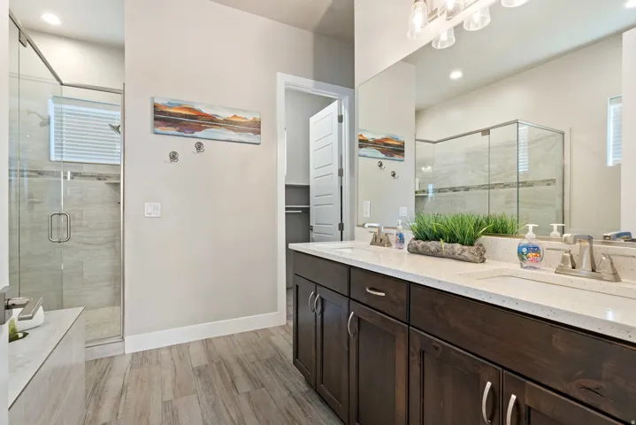 Bathroom featuring a dual vanity with dark wood cabinetry and light-toned countertops