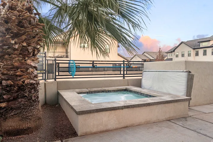 In-ground hot tub with stone coping and stucco surround