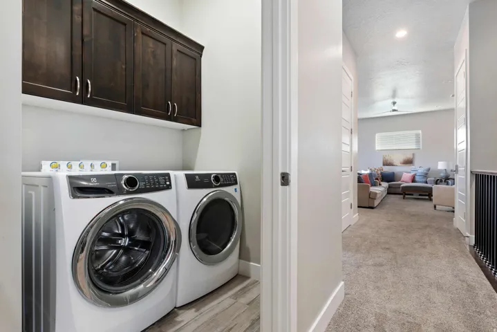 Dedicated laundry area featuring dark wood-finish cabinetry