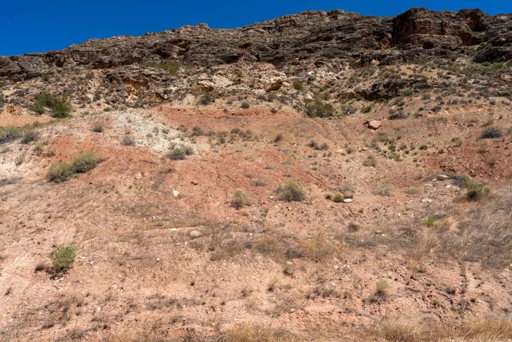 Expansive desert hillside featuring varied geological strata