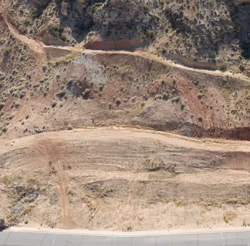 Expansive undeveloped lot featuring varied topography with natural rock formations and subtle vegetation