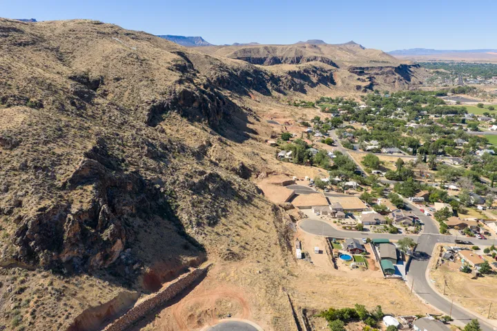 Expansive desert landscape featuring rugged mountains and a residential area with a curved road network