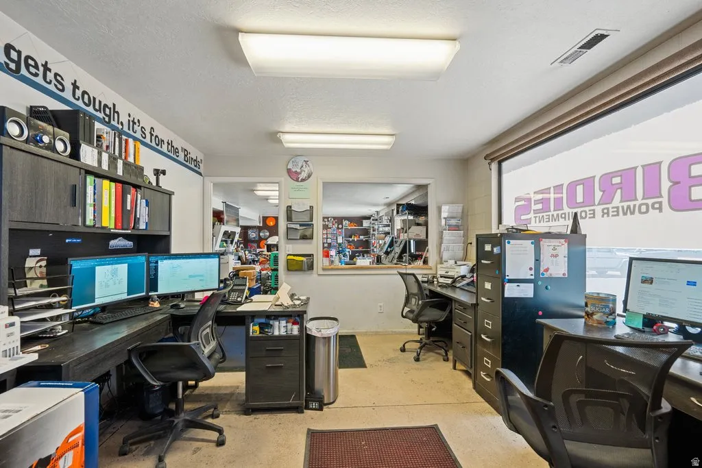 Office interior featuring a large window, recessed lighting, and a neutral wall color