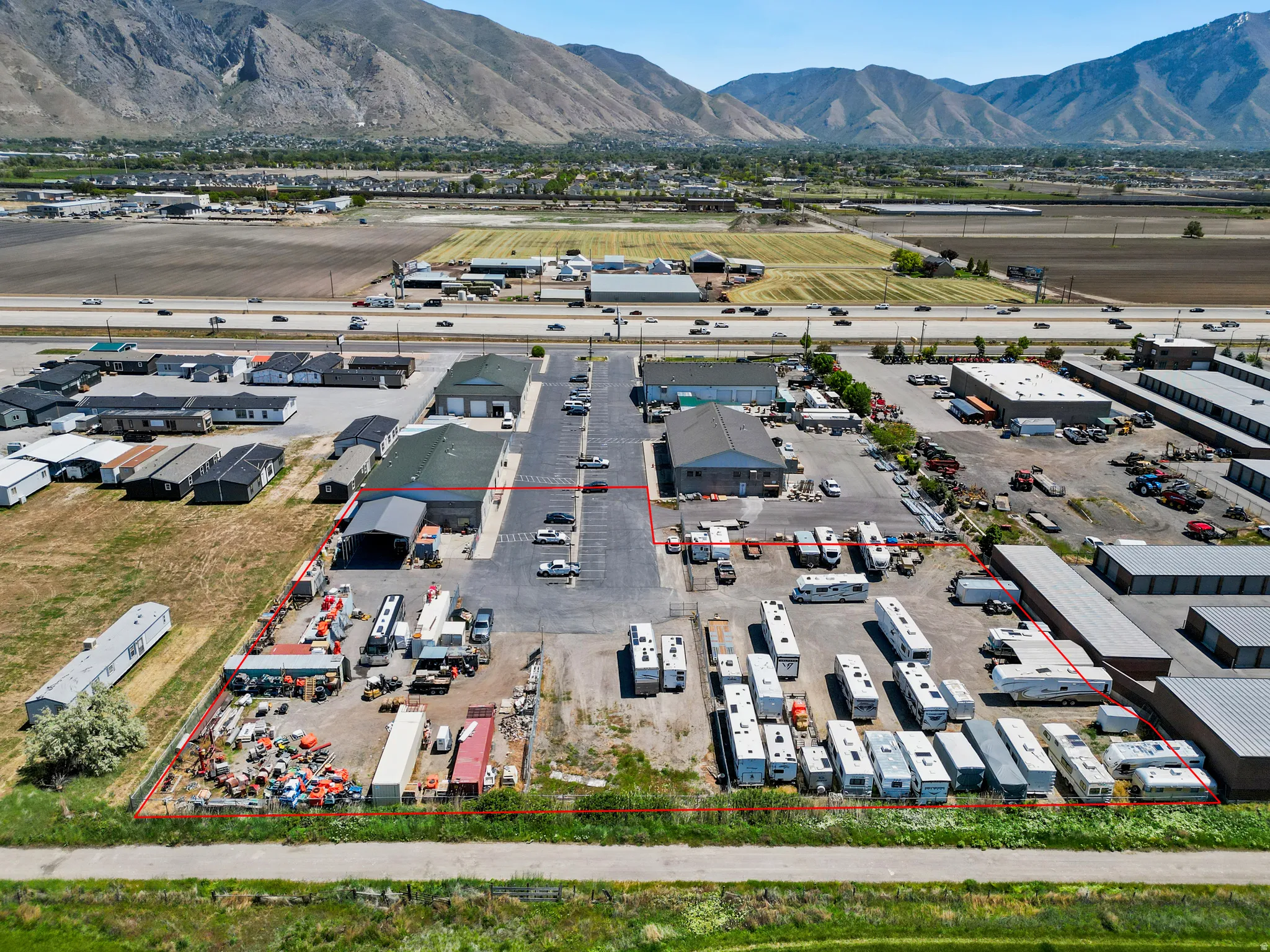 Expansive commercial property featuring block building, extensive paved parking areas, and designated outdoor storage