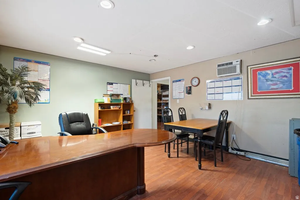 Spacious room featuring wood-finish flooring, recessed ceiling lighting, and neutral wall tones
