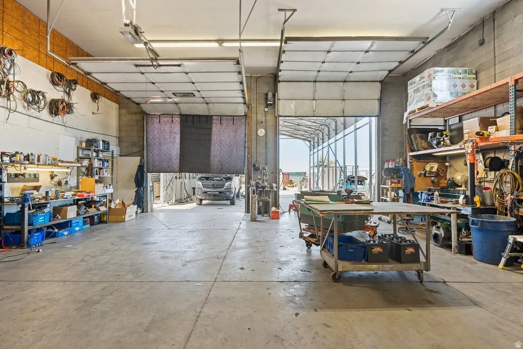 Spacious industrial interior featuring a concrete floor, high ceilings, and multiple overhead doors