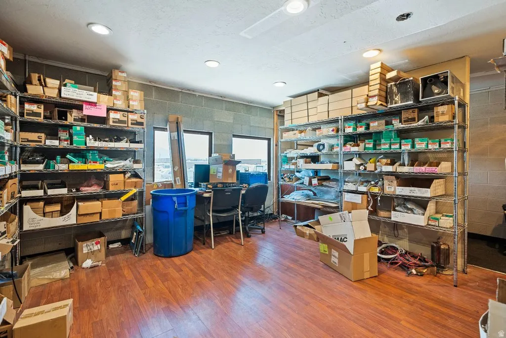 Spacious room with wood-finish flooring, recessed lighting, and ample shelving for storage