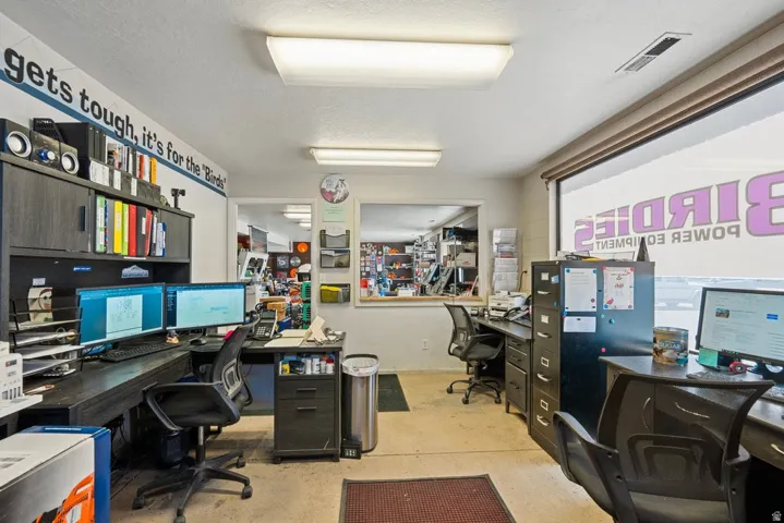 Office interior featuring a large window, recessed lighting, and a neutral wall color